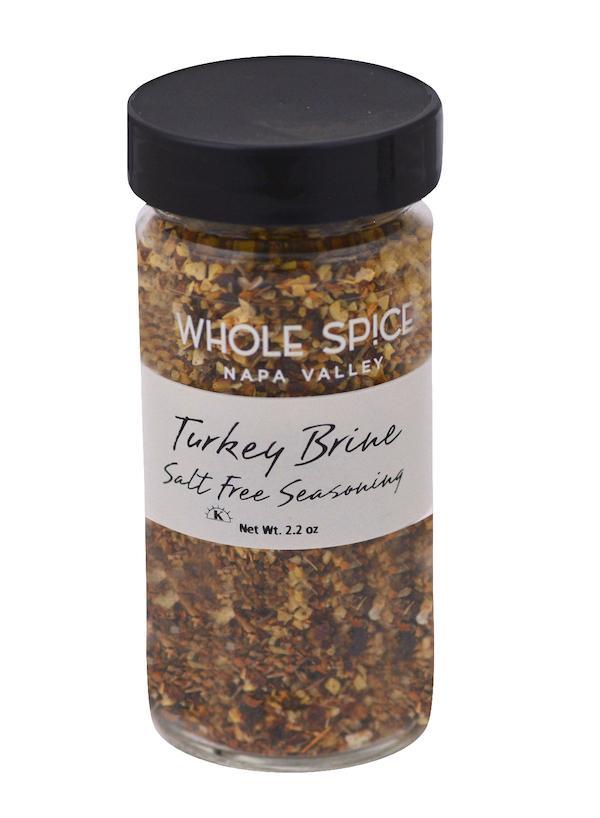 A clear glass jar with a black lid, labeled Whole Spice Inc. Salt-Free Turkey Brine Seasoning, contains a colorful blend of dried spices for moist turkey. Net weight: 2.2 oz.