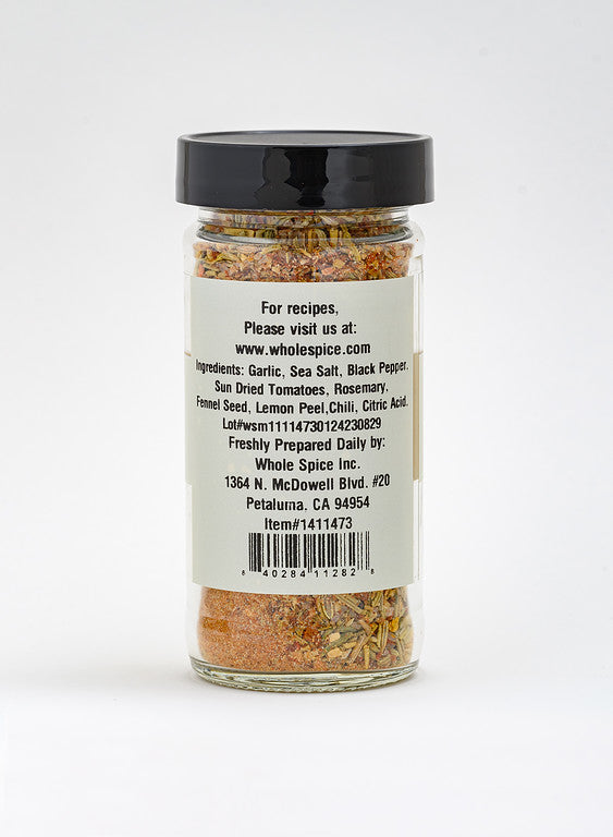 A clear spice jar with a black lid shows a label for Napa Valley Rub by Whole Spice Inc., listing garlic, sea salt, black pepper, sun dried tomatoes, and rosemary. The versatile blend includes contact info and a website for recipes.