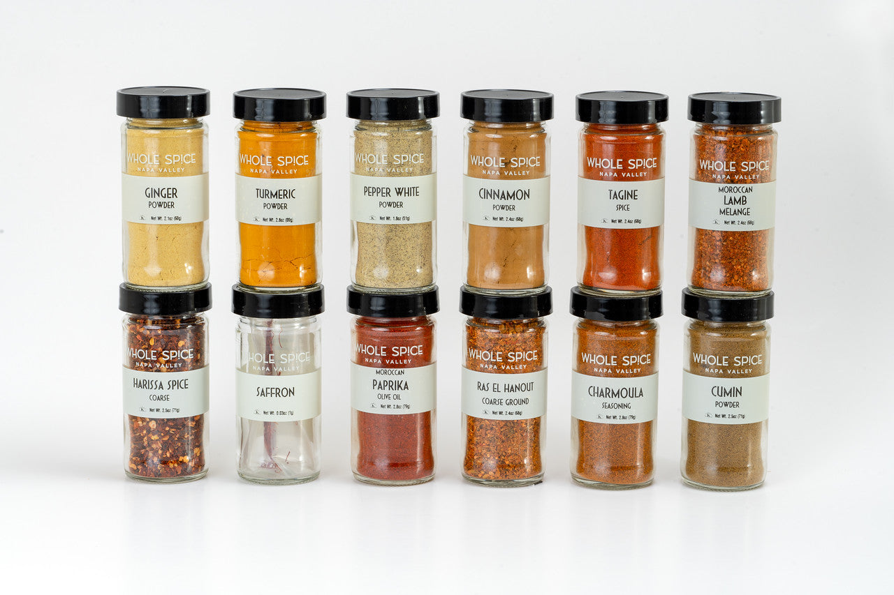 Experience the Whole Spice Moroccan Spice Gift Set by Whole Spice Inc., featuring 12 glass jars with authentic spices like ras el hanout, harissa, and chaarmoula—perfect for enhancing your Moroccan-inspired dishes.