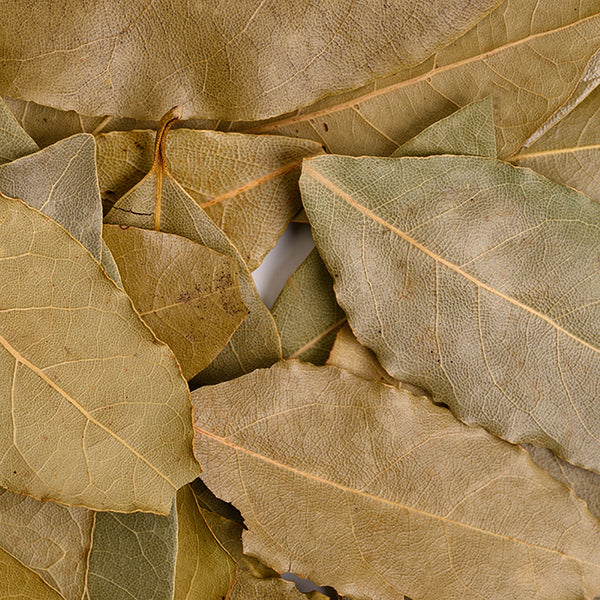 A close-up of Whole Spice Inc. Bay Leaves Whole Organic, overlapping to reveal their textured surfaces and visible veins in various green, brown, and tan shades.