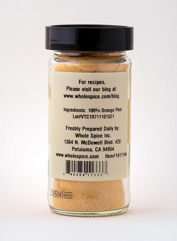 Whole Spice Inc. Orange Peel Powder comes in a clear glass jar with a black lid, containing 100% orange peel for bold citrus flavor. The label features company and blog information.