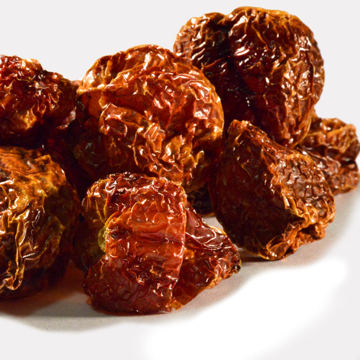 A close-up of Whole Spice Inc. Habanero Chili Whole—several dried, wrinkled, reddish-brown chilies on a white surface, celebrated for their intense heat and high Scoville rating.