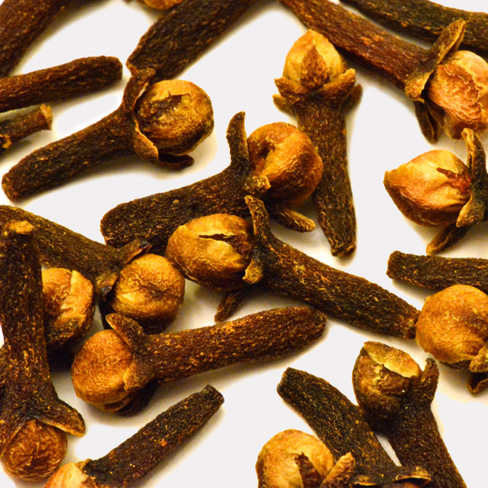 Cloves Whole by Whole Spice Inc. are aromatic dried Syzygium aromaticum buds with dark brown, woody stems and rounded tops, displayed on a white background.