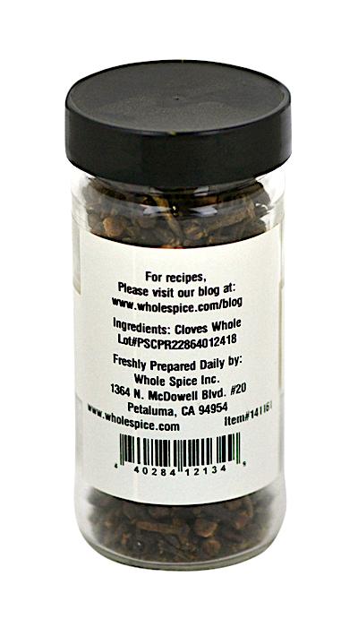 A clear spice jar with a black lid contains Cloves Whole from Whole Spice Inc.; the label lists clove buds as the ingredient and provides company contact details plus a website for recipes.