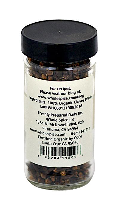 A clear glass jar with a black lid contains Whole Spice Inc. Cloves Whole Organic—100% organic Syzygium aromaticum buds. The label includes company info, website, and Petaluma, California address.