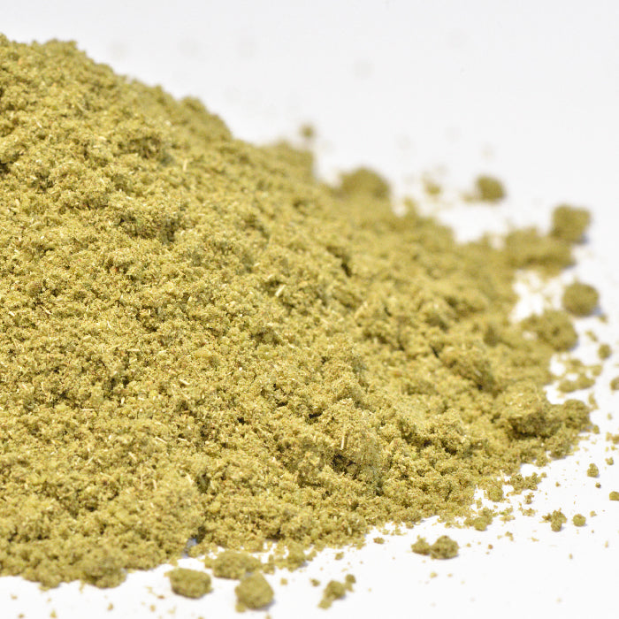 A close-up of Whole Spice Inc. Fennel Seed Powder Organic—a light greenish-yellow powder with a fine to slightly coarse texture, made from ground organic fennel seeds—on a white surface.