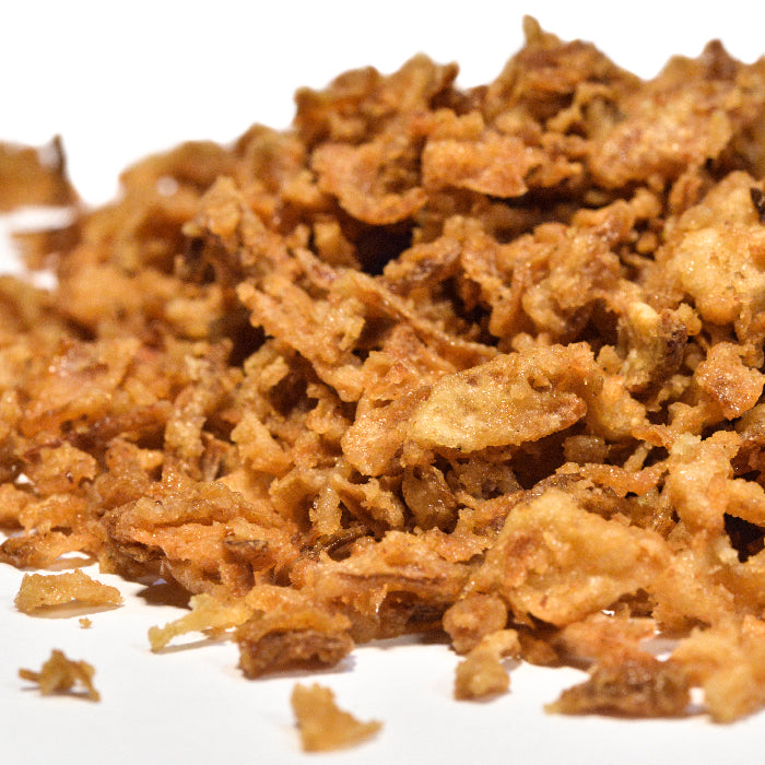 A close-up of crispy, golden brown Fried Onion by Whole Spice Inc. on a white background—perfect for adding savory dried onion flavor to your favorite dishes.