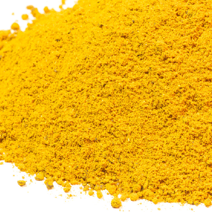 A close-up of a mound of bright yellow Hawaj Soup Blend by Whole Spice Inc. on a white background. The finely ground spice mix is unevenly spread, highlighting its vibrant color and grainy texture.