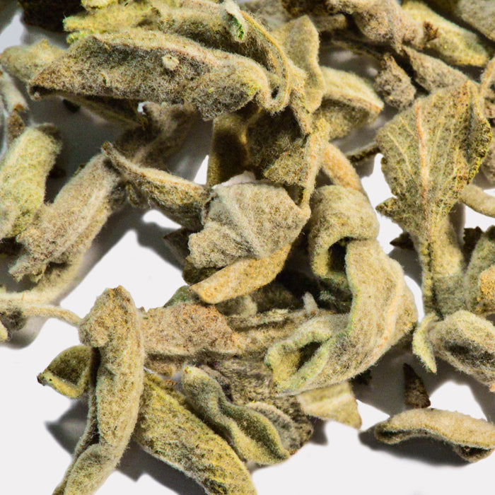 Close-up of Sage by Whole Spice Inc.—dried leaves with fine, silvery-white hairs and curled, slightly twisted shapes. A popular Mediterranean culinary herb shown against a white background.