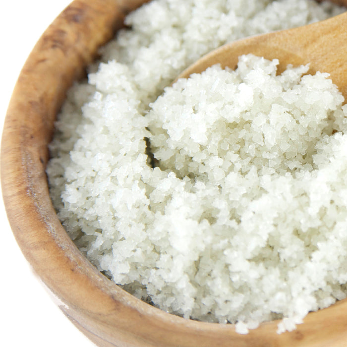 A bowl of Whole Spice Inc. Sel Gris Salt with a spoon—perfect for adding a gourmet touch to your cooking salt collection.