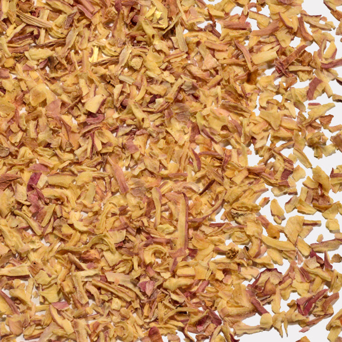 A close-up of Whole Spice Inc. Shallots shows scattered dehydrated, chopped pieces in light yellow and purple hues spread across a white background.